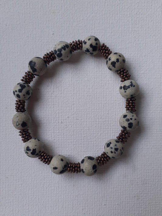 Bracelet with dalmatian jasper and copper beads on a white background