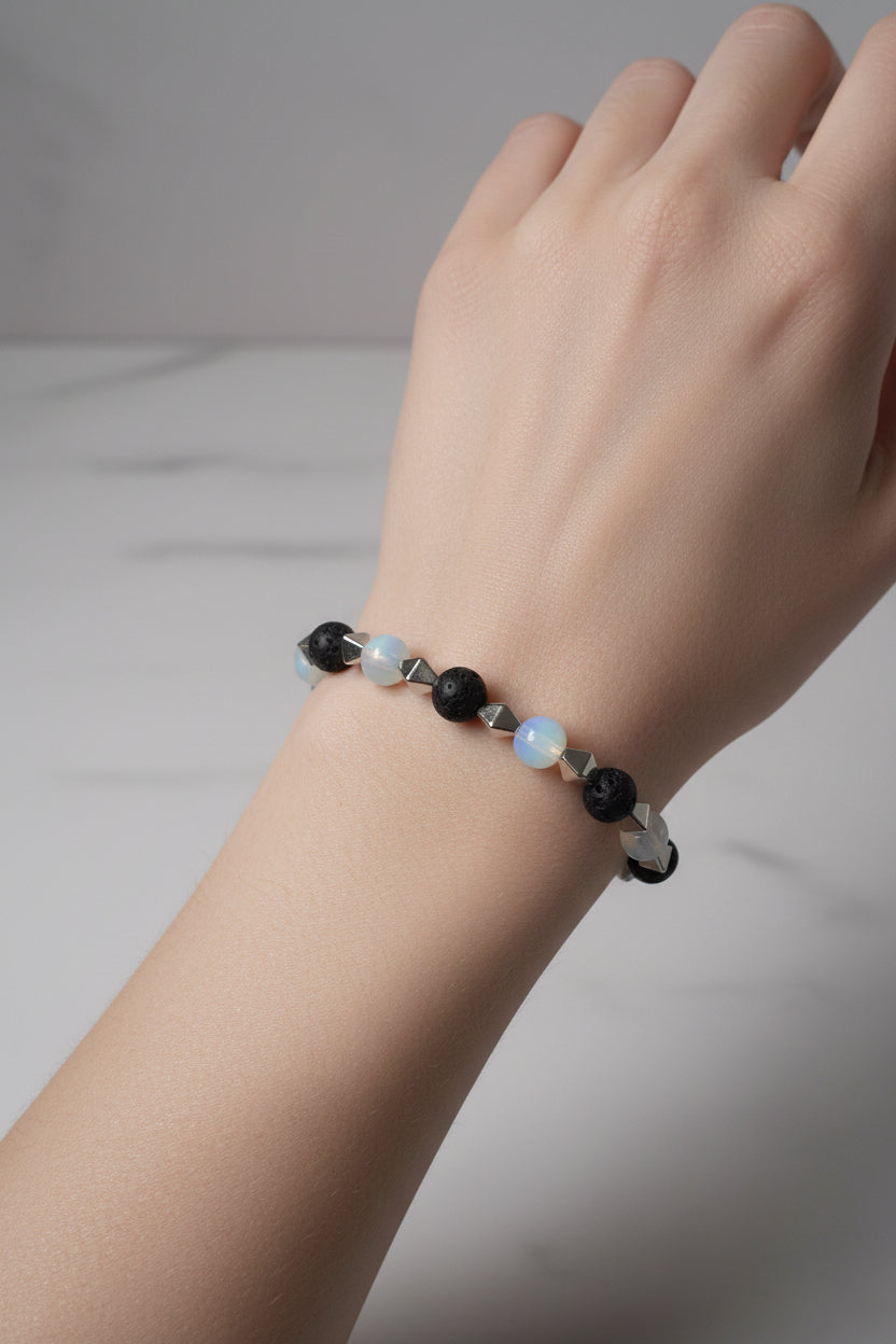 Bracelet with black, white, and silver beads on a gray background