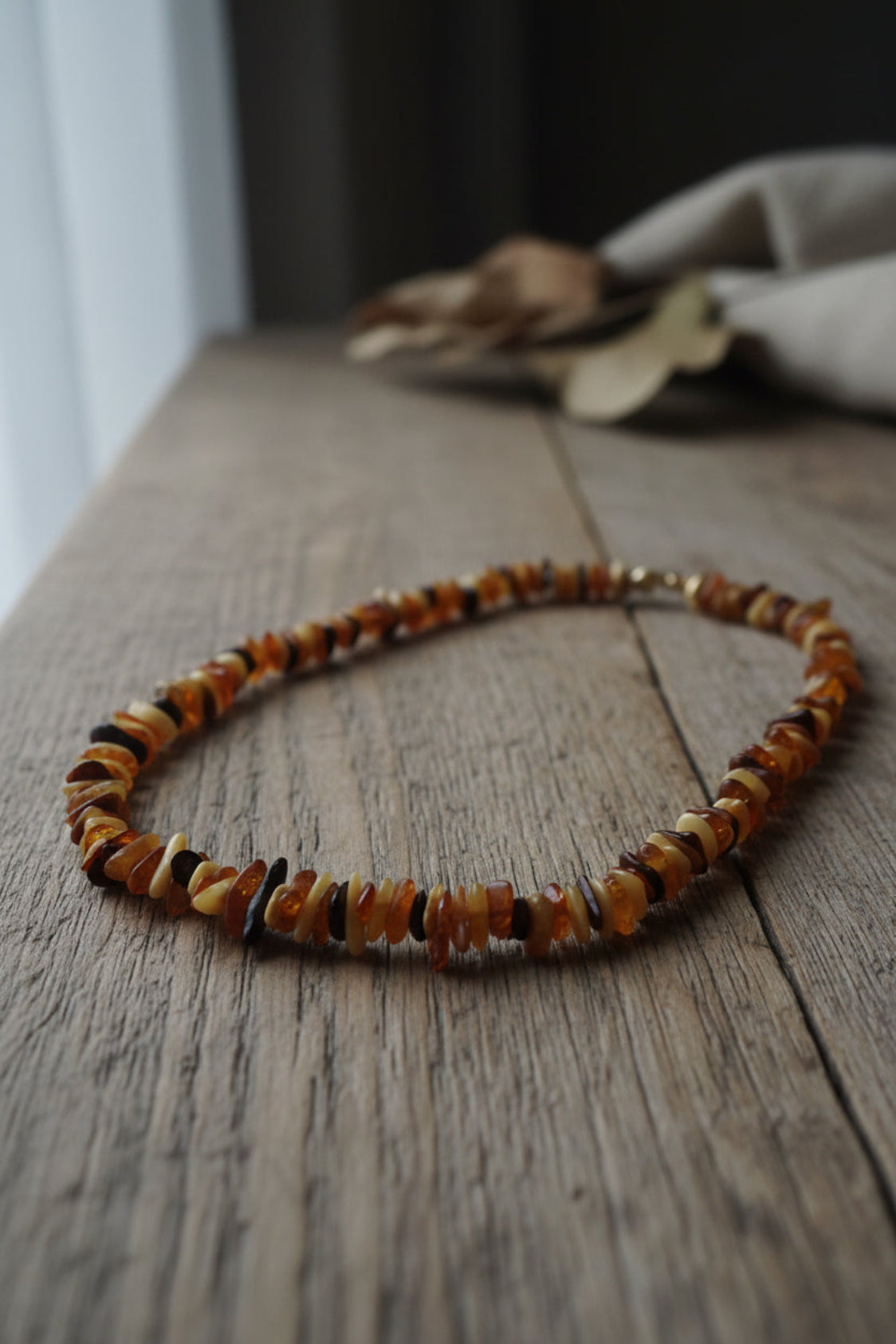 Necklace with amber-colored beads on a wooden surface