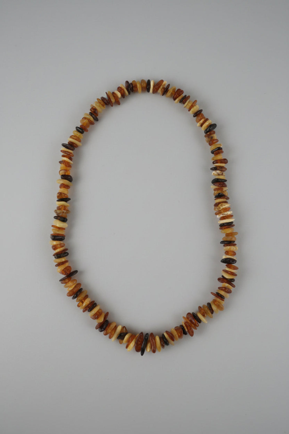 Necklace with multicolored beads on a gray background