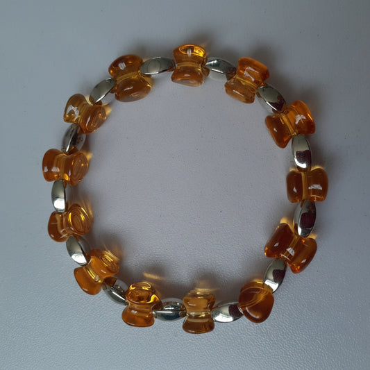 Bracelet with orange and silver beads on a light gray background