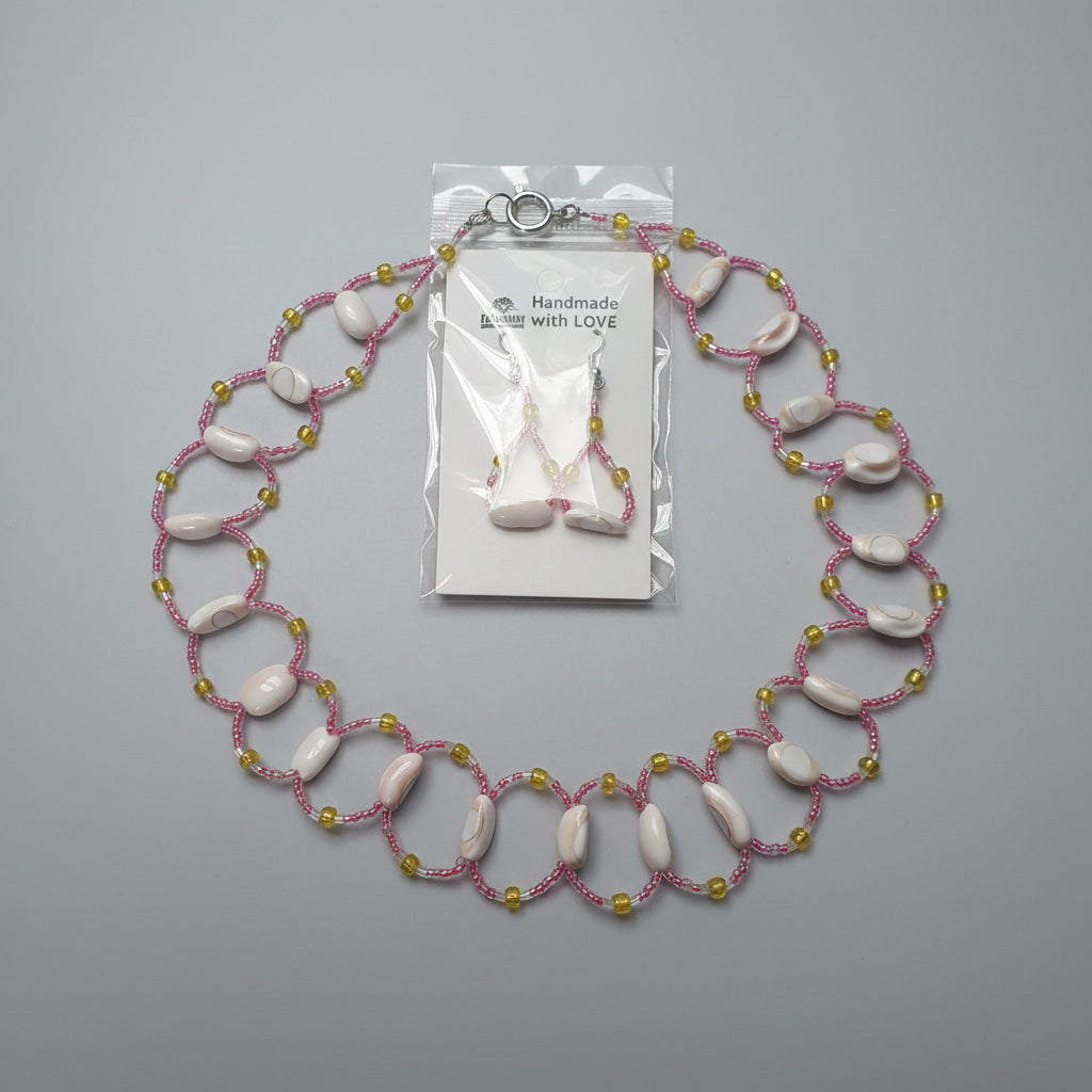 Necklace with pink and yellow beads on a white card