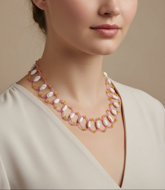 Necklace with pink and white beads worn by a person against a neutral background