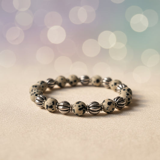 Bracelet with alternating silver and speckled beads on a light gray background