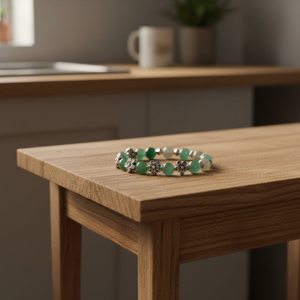 Green and silver bracelet on a wooden table with a blurred kitchen background