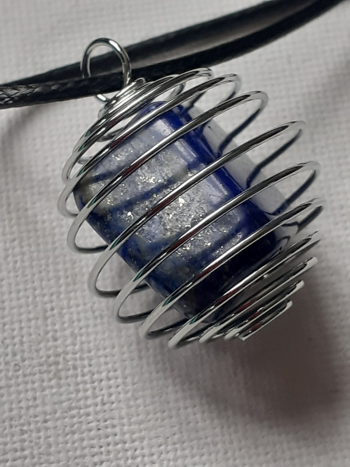 Metallic coil with blue core on a white background