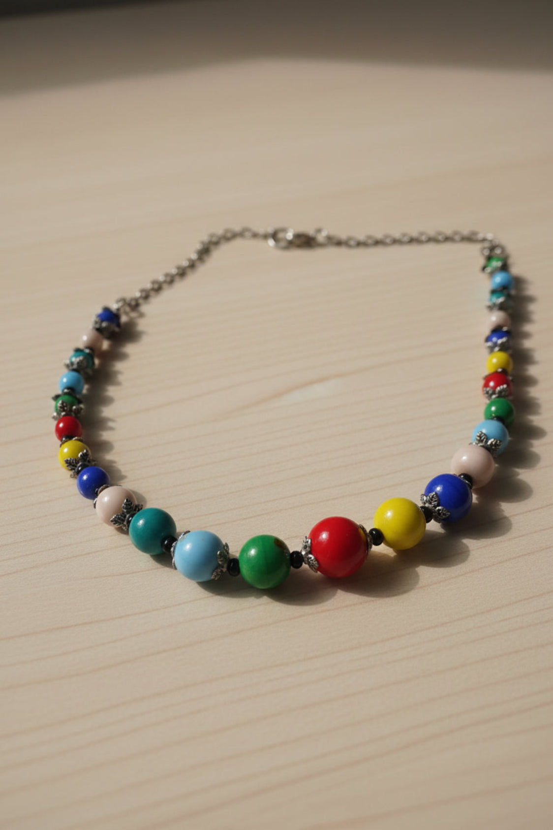 Colorful beaded necklace on a light gray background