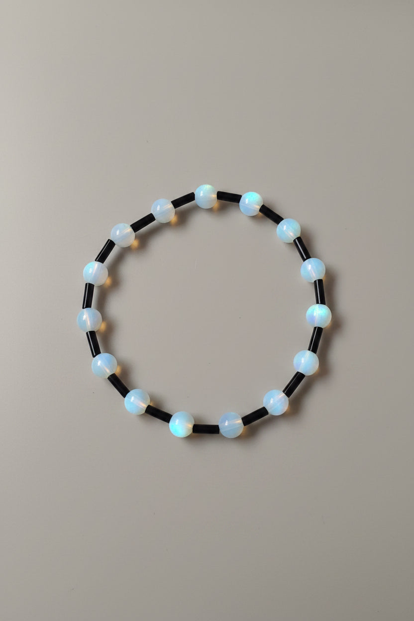 Beaded bracelet with black and white beads on a light gray background