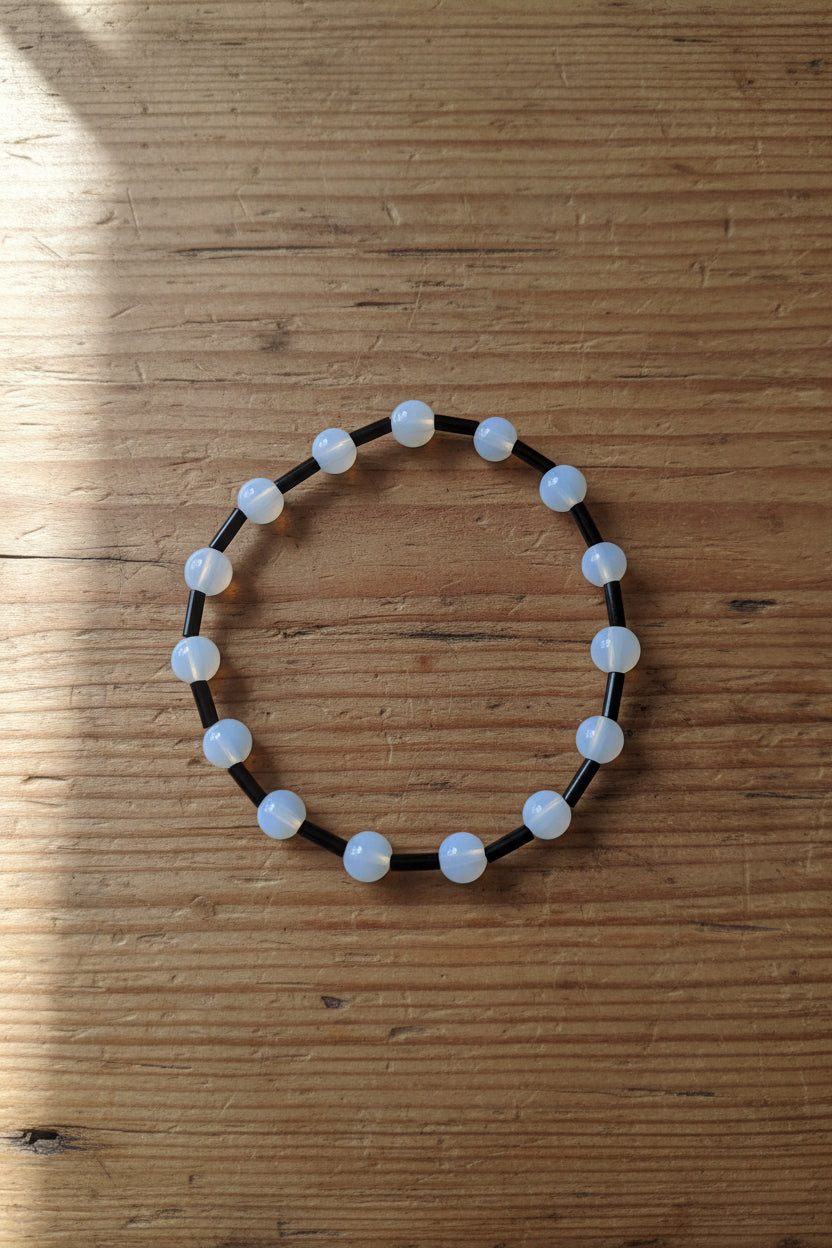 Beaded bracelet with black and white beads on a light gray background