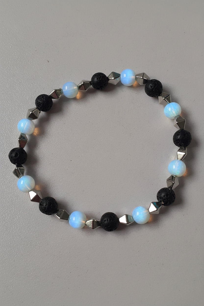 Bracelet with black, white, and silver beads on a gray background