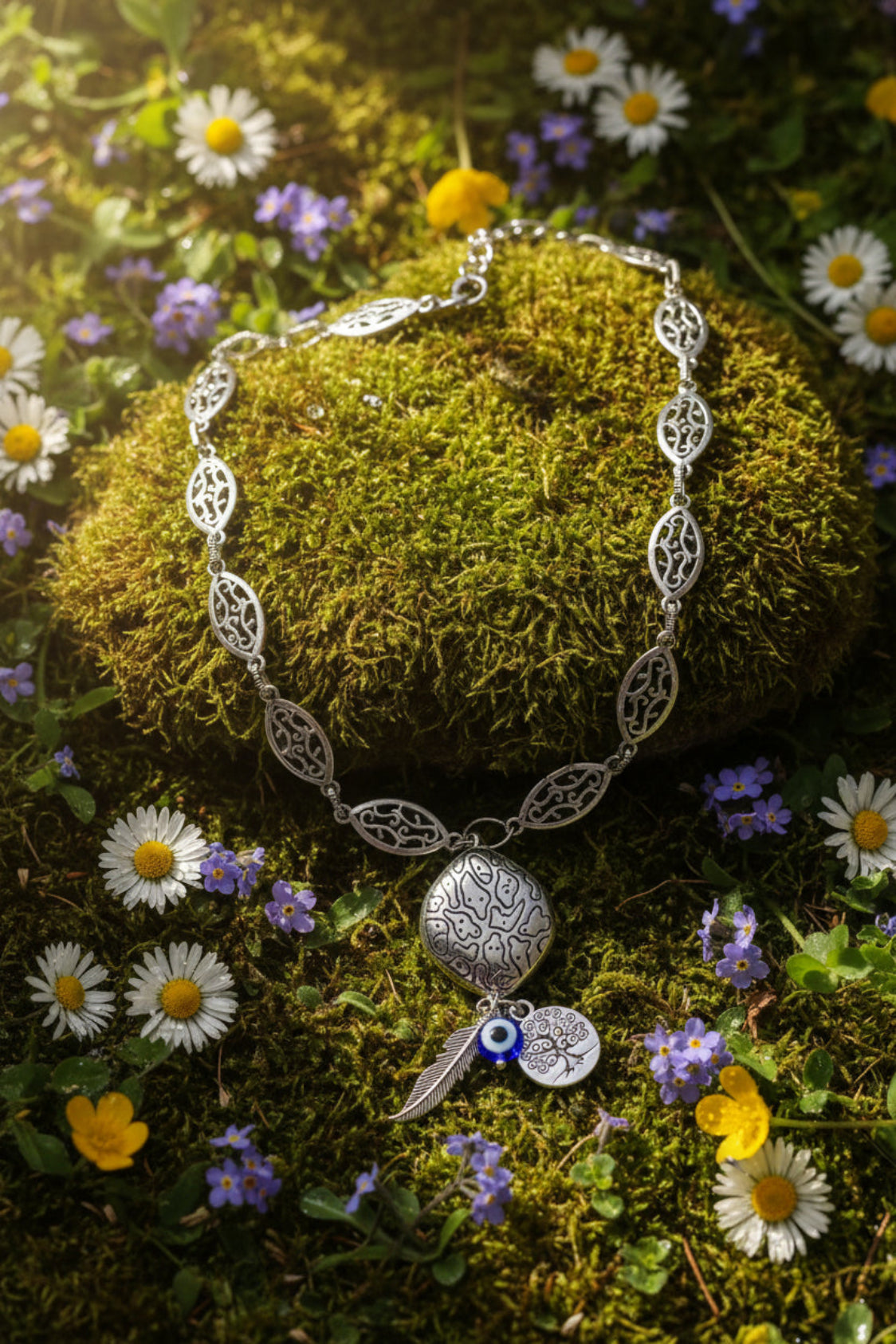 Silver-tone necklace with decorative elements on a gray background