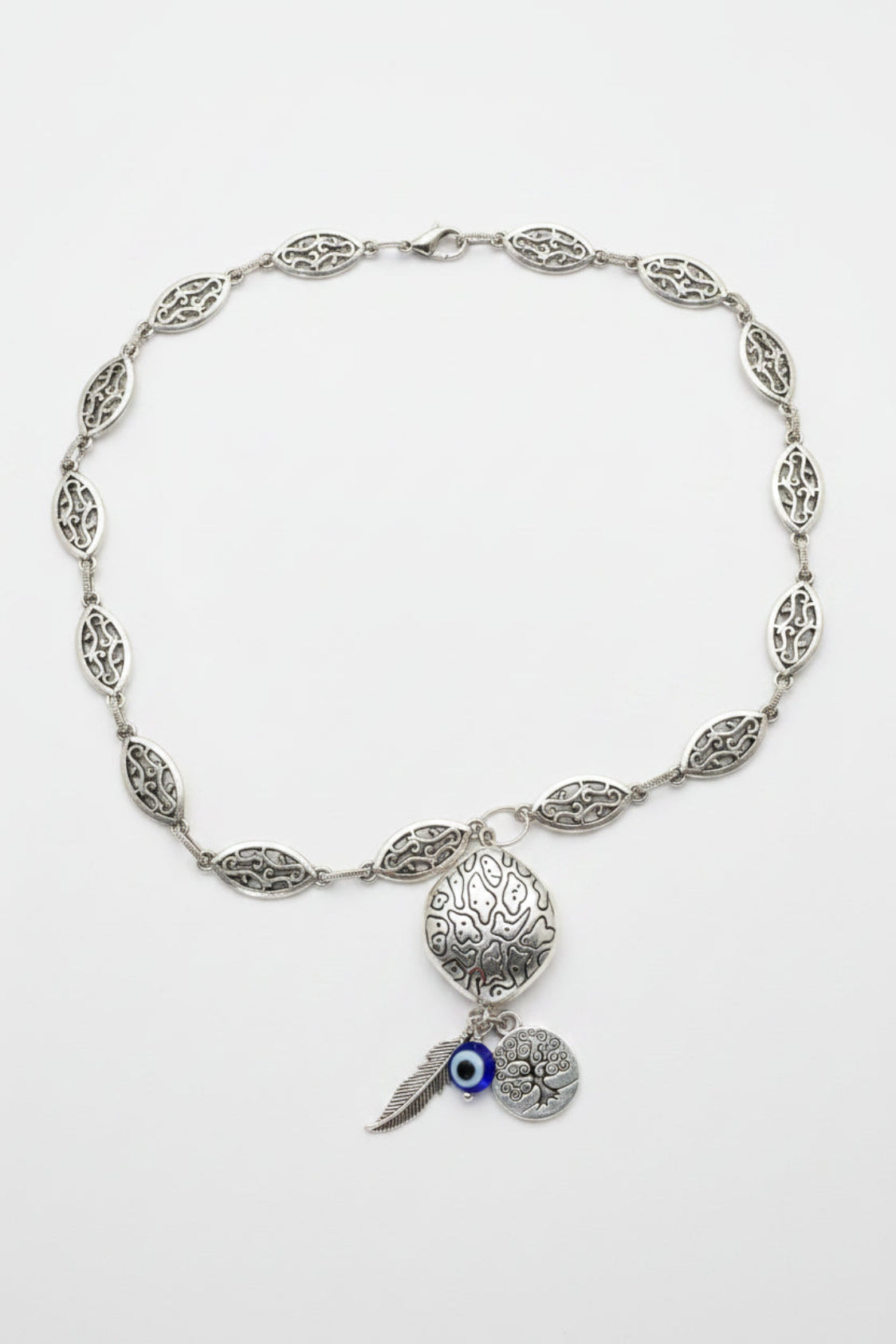 Silver necklace with evil eye charm on a white background