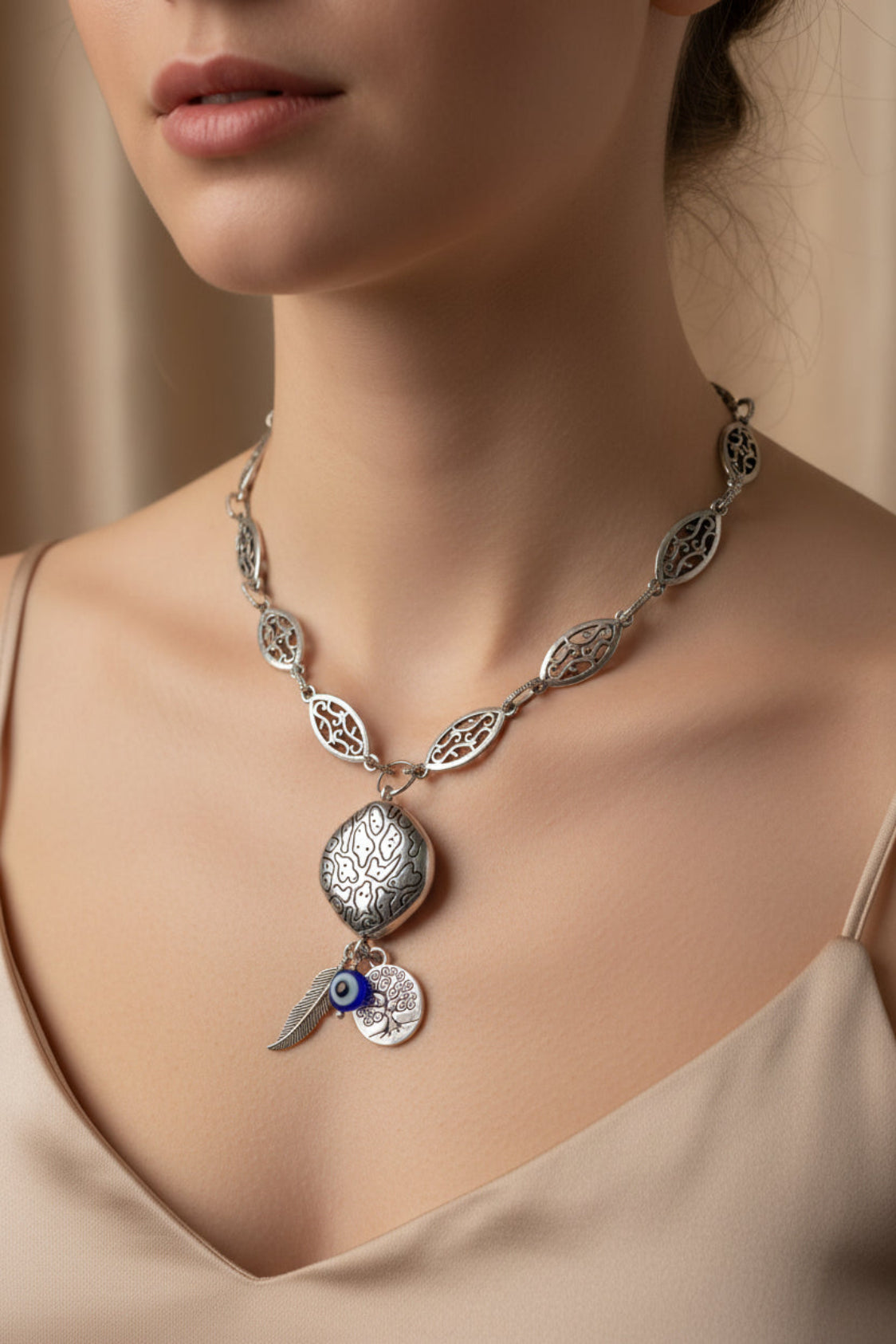 Silver necklace with a pendant on a model against a neutral background